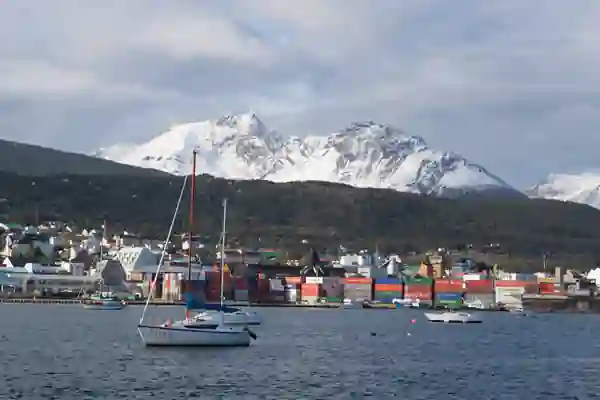 Port de Ushuaia, avec des voiliers au mouillage, le port commercial, et en arrière-plan les montagnes enneigées