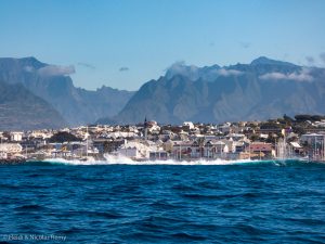 L'entrée du Cirque de Cilaos, au-dessus de laquelle culmine le Piton des Neiges, et le port de St-Pierre en avant-plan.
